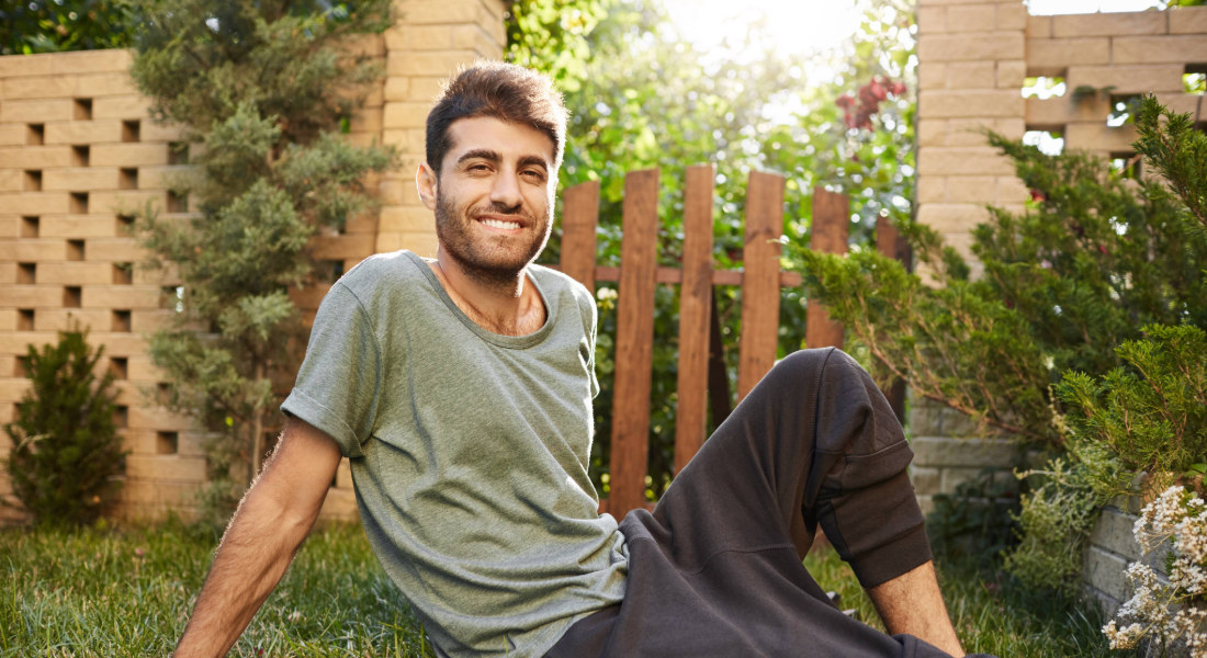 guy sitting in a backyard with the sunshine over his shoulder