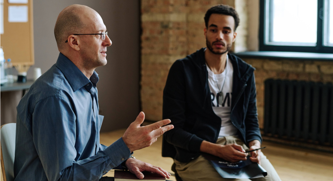 two men talking inside a room