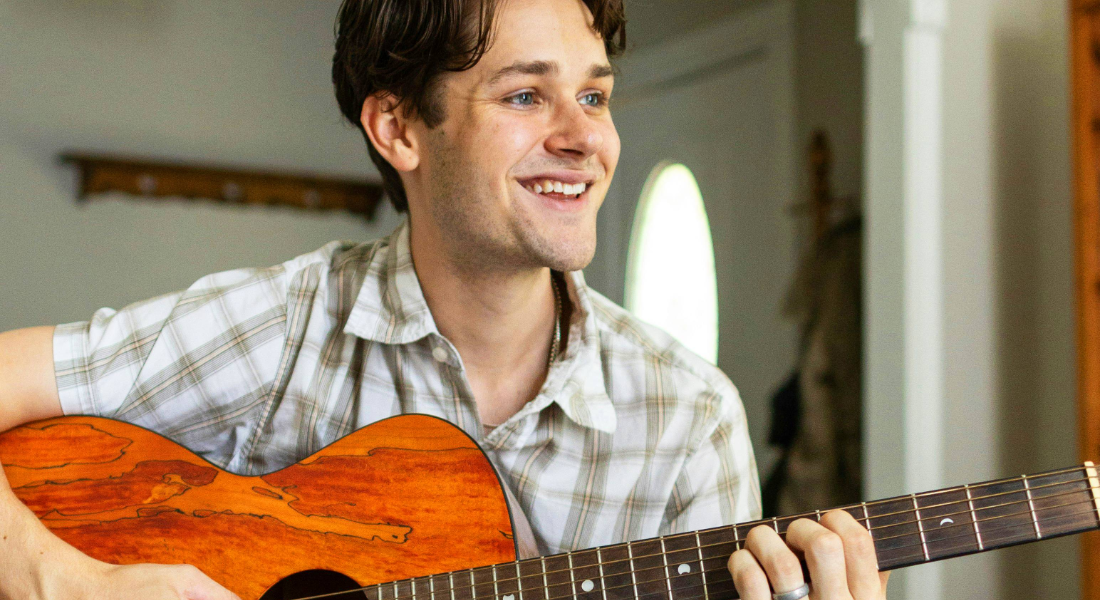 young adult man playing the guitar
